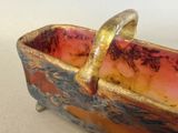 a small bowl with a handle that is sitting on top of a table
