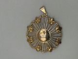 a gold pendant with a picture of a man on it