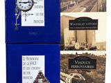 trois livres sur un fond blanc, avec une horloge posée dessus