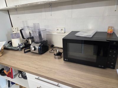 un micro-ondes et un mixeur posés sur le plan de travail d'une cuisine