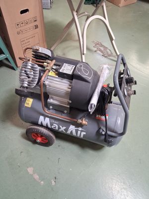 un petit compresseur d'air posé par terre à côté d'un chariot