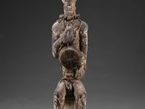 une image d'une statue en bois représentant un homme tenant un bébé
