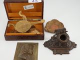 Plusieurs objets anciens en laiton sont exposés sur une surface blanche