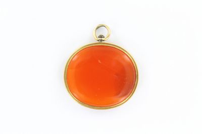 un pendentif en or et cornaline sur fond blanc