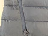 grey down filled vest with zippers and a tag on the front