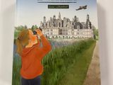 un livre sur lequel figure l'image d'une fillette regardant un château