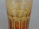 a glass cup with a gold design on it