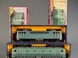 two green trains sitting in a box on a table