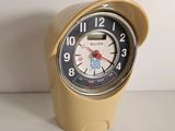 a small yellow clock sitting on a white table