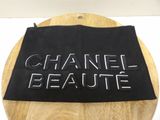 chanel beauute bag on a wooden table with a black cloth