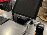 une photo représentant une caisse enregistreuse et un téléphone portable posés sur un comptoir