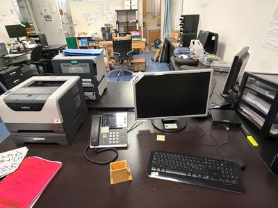 a desk with a computer, printer, and other office supplies on it