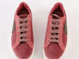 the pink sneakers are lined up on a white surface