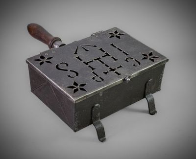une petite boîte en métal munie d'une poignée en bois