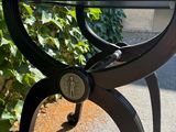 a glass table with a clock on it sitting on a sidewalk