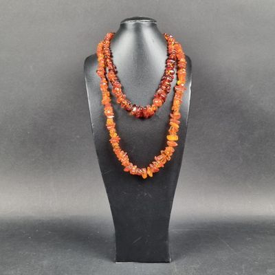 un collier composé de perles de cornaline et de perles orange, présenté sur un mannequin noir