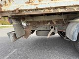 a rusted truck that is parked on the side of the road