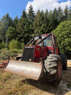 a red tractor that is parked in the grass