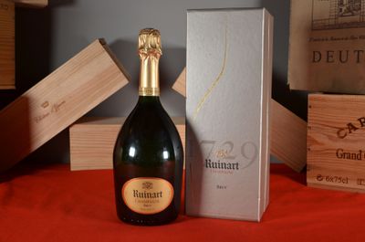une bouteille de champagne posée sur une table à côté d'un coffret
