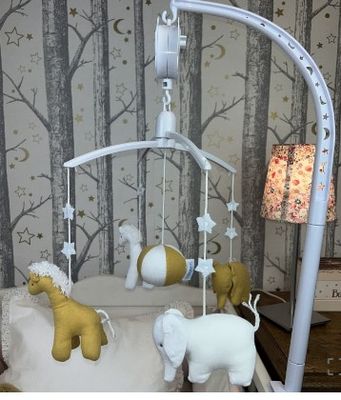 a baby crib with a mobile with animals hanging from it
