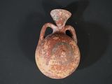 a brown vase that is sitting on a black surface