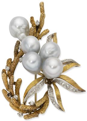 a close up of a brooch with pearls and leaves