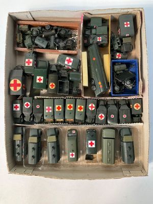 une boîte remplie de véhicules militaires miniatures et d'autres objets militaires