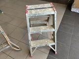 a ladder that is sitting on the floor next to a chair