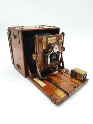 un vieil appareil photo posé sur un support en bois