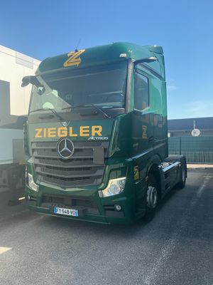 a green truck that is parked in a parking lot
