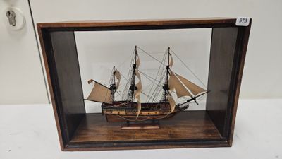 a wooden model of a ship in a glass case