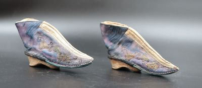 two pairs of shoes are sitting on top of a black surface