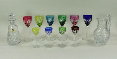 de nombreux verres à vin et carafes de différentes couleurs sur la table