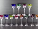 de nombreux verres à vin de différentes couleurs alignés sur une table