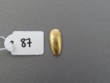 a tag with a gold nail on it next to a gold nail