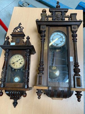 two clocks that are sitting on a wooden table