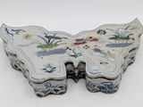 a white butterfly shaped box with blue and white designs on it