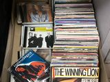 une boîte en carton remplie de CD et des CD par terre