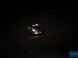 un gros plan d'une bague posée sur une table dans l'obscurité