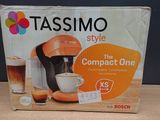 une boîte posée sur une table, sur laquelle se trouve une cafetière