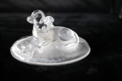 une figurine en verre représentant un chien assis sur une assiette