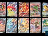 Les cartes Pokémon sont alignées sur une surface noire.