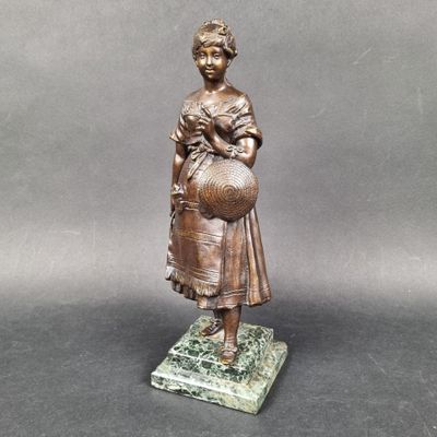 bronze statue of a woman holding a ball on a marble base