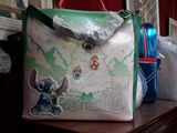 a handbag with a stitching design on it sitting on a dresser