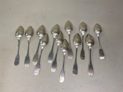 six cuillères en argent sont alignées sur une table