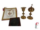 an image of a group of items including a cross, a candle holder, and a book