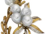 un gros plan d'une broche ornée de perles et de feuilles