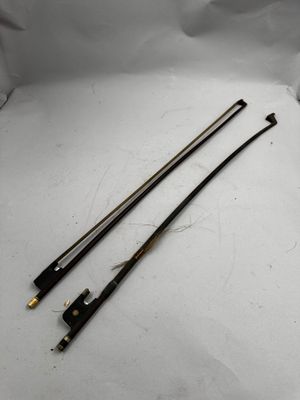 une paire de deux fils métalliques noirs et dorés sur une surface blanche