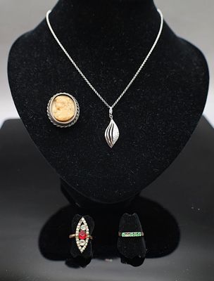 un collier, des boucles d'oreilles et une broche exposés dans une vitrine