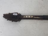 a close up of a wooden stick with a sticker on it